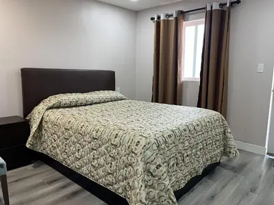 a bedroom with a bed with a comforter and a window at Kluane Park Inn in Haines Junction