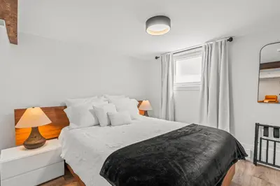 a white bedroom with a bed and a window at Blue Spruce Den - Vernon in Vernon