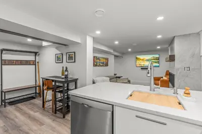 a kitchen and living room with a white counter top at Blue Spruce Den - Vernon in Vernon