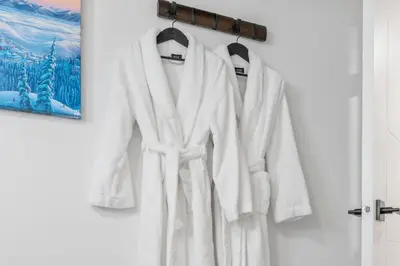 a white robe hanging on a wall at Blue Spruce Den - Vernon in Vernon