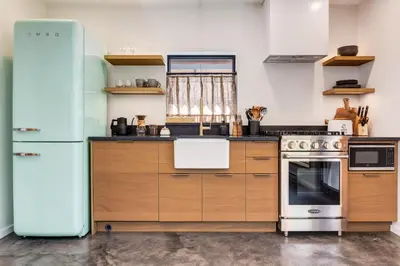 a kitchen with wooden cabinets and a refrigerator at Fogged Inn in Ucluelet