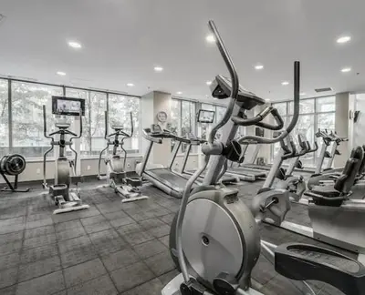 a gym with several treadmills and elliptical machines at Downtown,FreeParking,Pool,Comfy,OceanMontain View in Vancouver