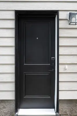 a black door on the side of a house at Cozy 2BR Suite with Kitchen, AC Near U of C, Winsport, Banff and Hospitals in Calgary