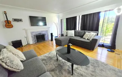 a living room with a couch and a fireplace at Private 2 BR Cozy Home Private Parking Free Sparkling and Goodies! 4 mins from Metrotown in Burnaby