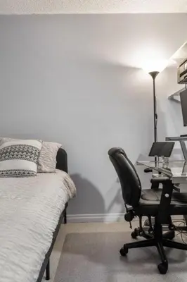 a bedroom with a desk and a chair next to a bed at Cozy & Spacious 2BR in Downtown very close to Stampede and 17th Ave with Parking and AC in Calgary