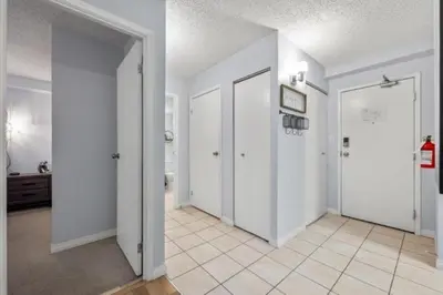 an empty hallway with white walls and white doors at Cozy & Spacious 2BR in Downtown very close to Stampede and 17th Ave with Parking and AC in Calgary