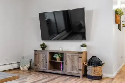a living room with a television on a wall at Cozy & Spacious 2BR in Downtown very close to Stampede and 17th Ave with Parking and AC in Calgary