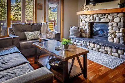 a living room with a couch and a fireplace at Creekside at Rundle Cliffs Lodge in Canmore