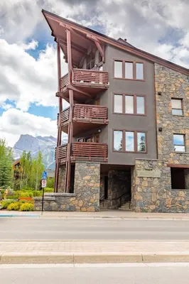 a building with a balcony on the side of it at Creekside at Rundle Cliffs Lodge in Canmore