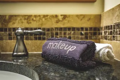 a bathroom sink with a purple mittruct on a counter at Creekside at Rundle Cliffs Lodge in Canmore