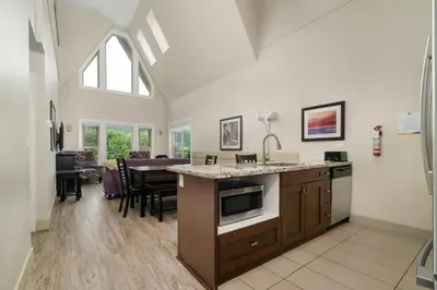 a kitchen and living room with a counter and a table at Harrison 3BR Pet friendly Unit in Harrison Hot Springs