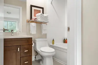 a bathroom with a toilet and a sink and a tub at Harrison 3BR Pet friendly Unit in Harrison Hot Springs