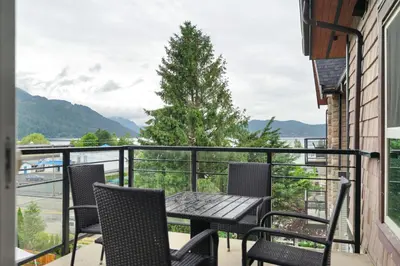 a balcony with a table and chairs and a view at Harrison 3BR Pet friendly Unit in Harrison Hot Springs