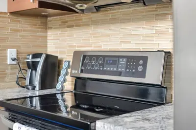 a stove top oven in a kitchen with a microwave at Harrison 3BR Pet friendly Unit in Harrison Hot Springs