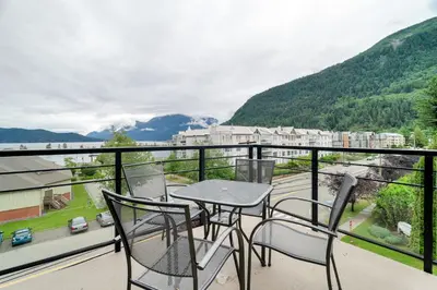 a table and chairs on a balcony with a view at Scenic 3BR unit in Harrison in Harrison Hot Springs