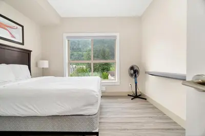 a white bedroom with a bed and a window at Scenic 3BR unit in Harrison in Harrison Hot Springs