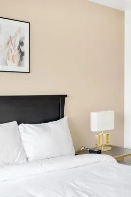 a bed with a black headboard and a table with a lamp at 4BR Unit In The Heart Of Harrison in Harrison Hot Springs