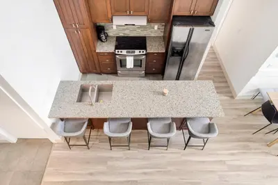 a kitchen with a counter with chairs around it at 4BR Unit In The Heart Of Harrison in Harrison Hot Springs