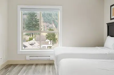 a bedroom with two beds and a window at 2BR Suite with Scenic Views in Harrison Hot Springs