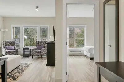 a living room with white furniture and windows at 2BR Suite with Scenic Views in Harrison Hot Springs