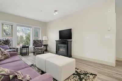 a living room with a couch and a fireplace at 2BR Suite with Scenic Views in Harrison Hot Springs