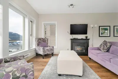 a living room with purple furniture and a fireplace at Serenity Luxe 2BR unit in Harrison in Harrison Hot Springs