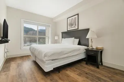 a white bedroom with a large bed and a window at Serenity Luxe 2BR unit in Harrison in Harrison Hot Springs
