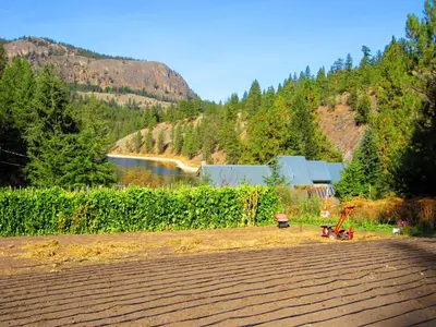 a view of a field with a river and trees at Mountain Springs Nature Retreat in Kaleden
