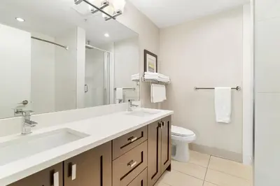 a white bathroom with a sink and a toilet at Chic Haven Stylish 3Bedroom in Harrison Hot Springs