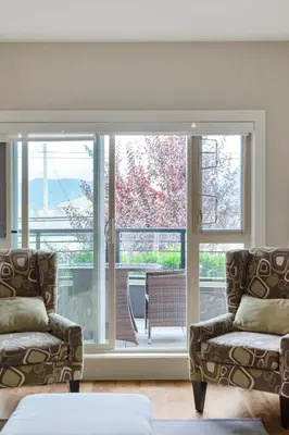 a living room with two chairs and a large window at Chic Haven Stylish 3Bedroom in Harrison Hot Springs