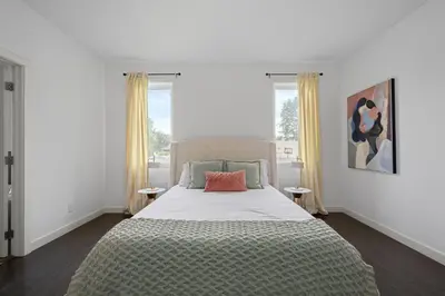 a bedroom with a bed and two windows at Charming 3 Bedrooms Home with BBQ- Deck- Fenced yard-Near WEM & River Valley in Edmonton