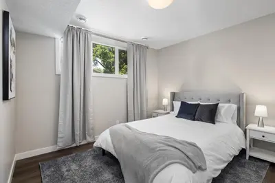 a white bedroom with a large bed and a window at 1 bedroom in Edmonton