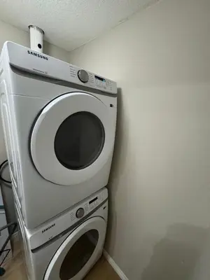 a washing machine in a corner of a room at The Bloom Haven in Edmonton