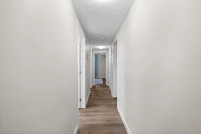a hallway with white walls and wood floors at 2-bedroom in Edmonton