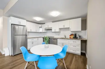 a kitchen with a white table and blue chairs at 2-bedroom in Edmonton