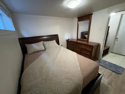 a bedroom with a bed and a dresser and a mirror at Nanaimo Nest in Nanaimo