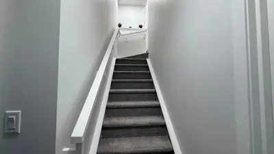 a stairway leading up to a room with white walls at Cozy & Quiet Calgary 2BR Suite in Calgary