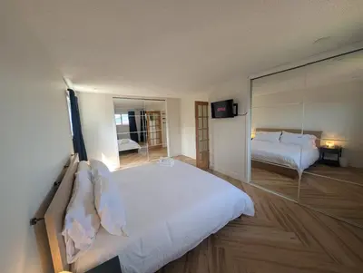 a bedroom with two beds and a large mirror at A Little R and R Private Sauna Cold and Hot Plunge in Calgary