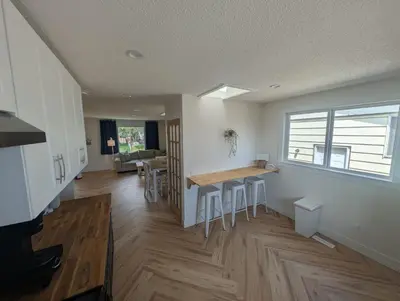 a kitchen and living room with a table and chairs at A Little R and R Private Sauna Cold and Hot Plunge in Calgary