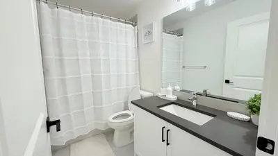 a white bathroom with a toilet and a sink at Casa Koko in Calgary