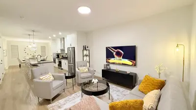 a living room with a couch and chairs and a kitchen at Casa Koko in Calgary