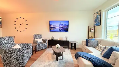 a living room with couches and a clock on the wall at La Maison de Koko in Calgary