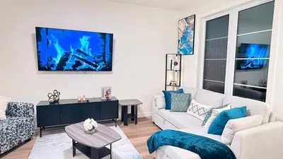 a living room with a couch and a tv on the wall at La Maison de Koko in Calgary