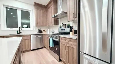 a kitchen with wooden cabinets and a stainless steel refrigerator at La Maison de Koko in Calgary