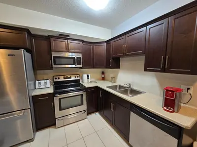 a kitchen with wooden cabinets and stainless steel appliances at Basement Suite Private Entry Fort McMurray in Fort McMurray