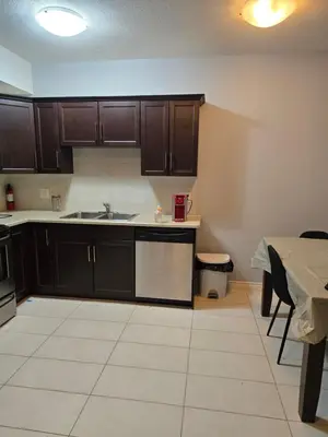a kitchen with dark brown cabinets and a table and a table and a tableablish at Basement Suite Private Entry Fort McMurray in Fort McMurray