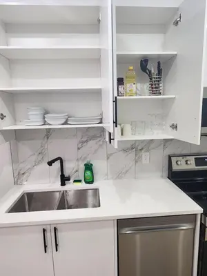 a kitchen with a sink and white cabinets at Home in Calgary in Calgary