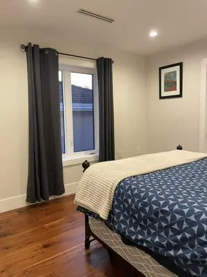 a bedroom with a bed and a window at 3 bed duplex in Kitsilano 10 min to airport and 10 min to downtown in Vancouver