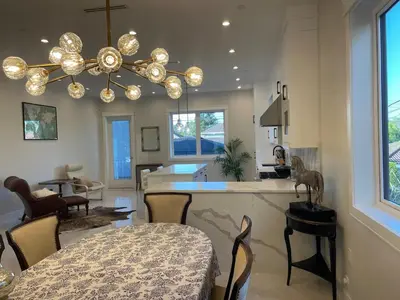 a kitchen and living room with a chandelier at 3 bed duplex in Kitsilano 10 min to airport and 10 min to downtown in Vancouver