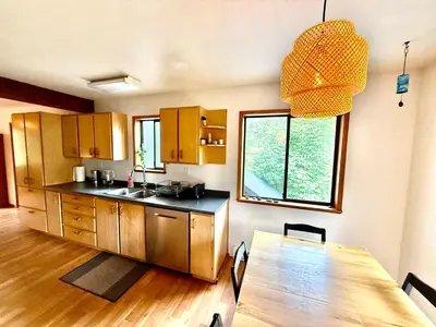 a kitchen with a table and a dining room at Eagles Nest - epic blufftop cabin Squamish in Upper Squamish
